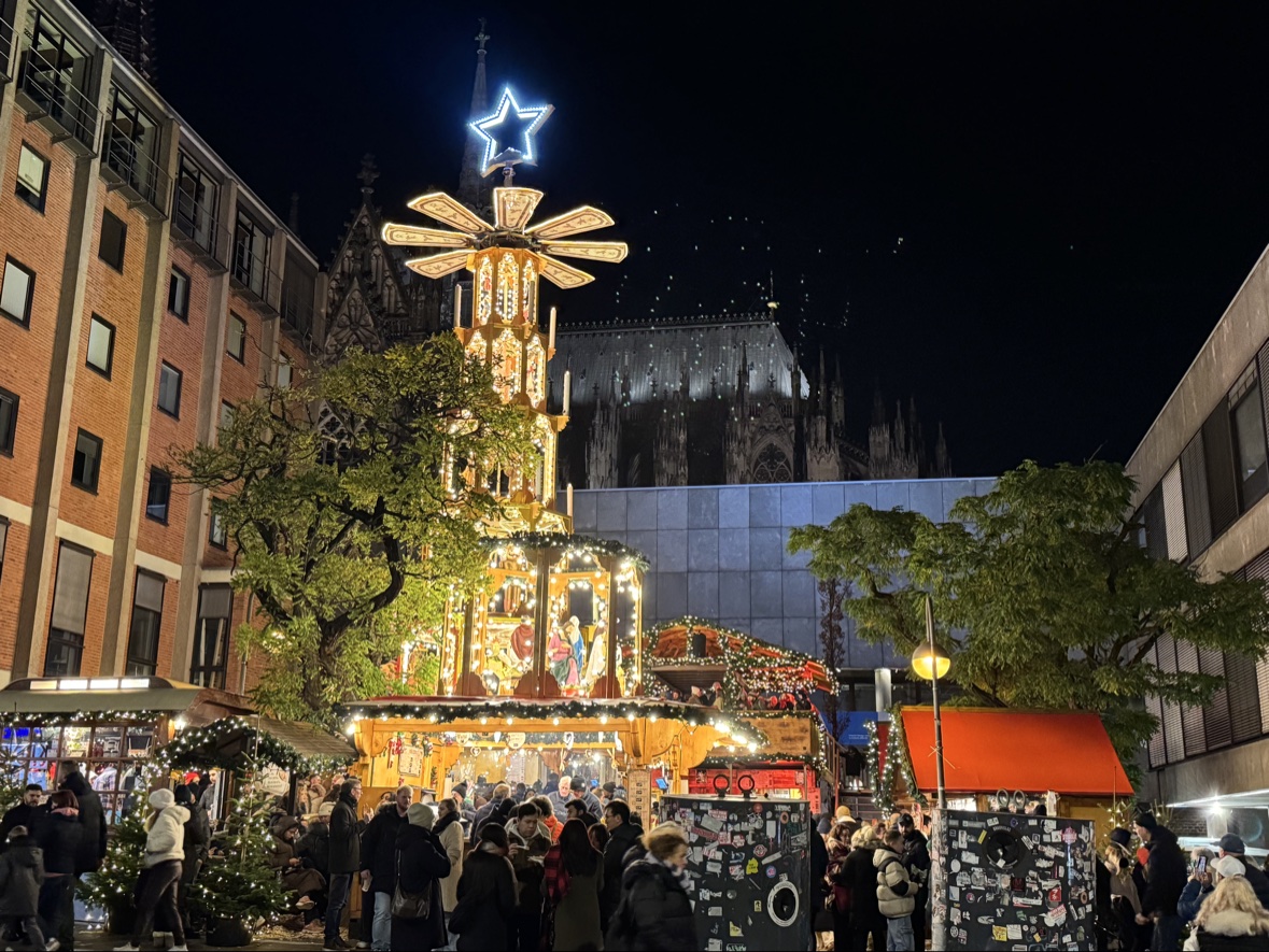 The towering Weihnachtspyramide, the German Christmas pyramid, at the Cologne Christmas market with the cathedral behind