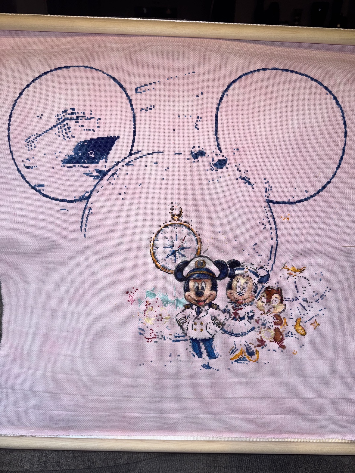 The bottom section of Anne Conrad&rsquo;s &ldquo;Magical Cruise&rdquo; cross stitch — Captain Mickey almost finished, Minnie and a chipmunk beside him, the compass rose stitched above